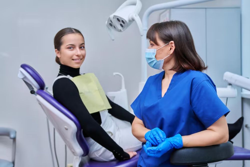 orthodontist consulting with a young patient about Invisalign and traditional braces treatment options.